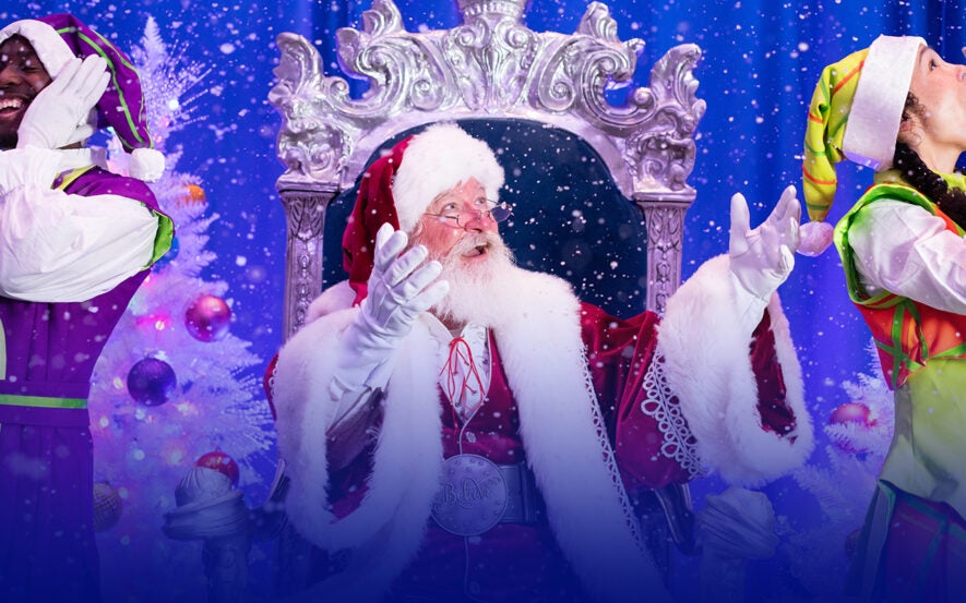 Santa with elves looking up at snow